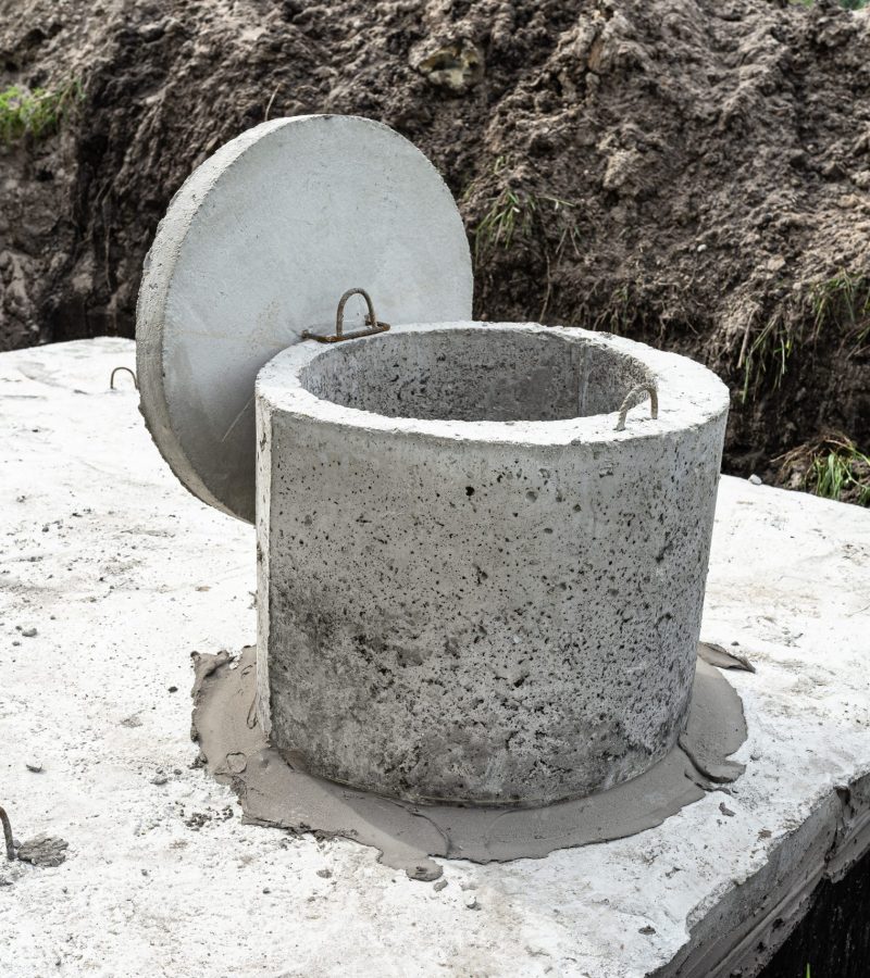 Concrete septic tank with a capacity of 10 cubic meters placed in the garden by the house, visible water below.